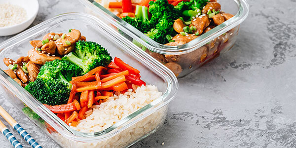 Prepared meals in a variety of containers sitting on counter