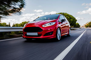New red car driving down highway