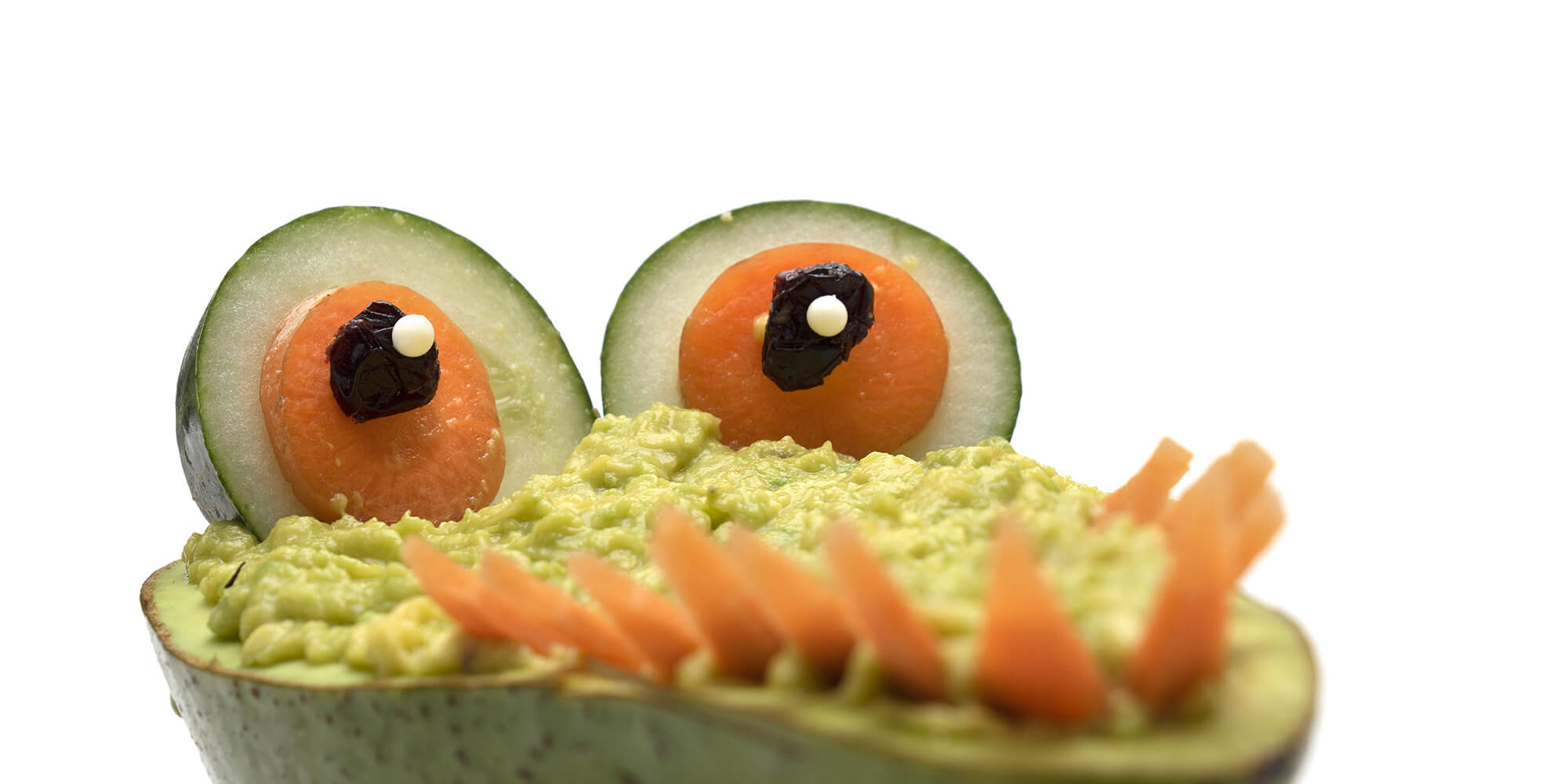 Avacado with carrots and cucumbers for eyes and carrot teeth