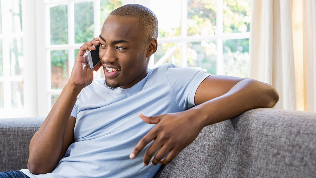 Man on cell phone sitting on couch