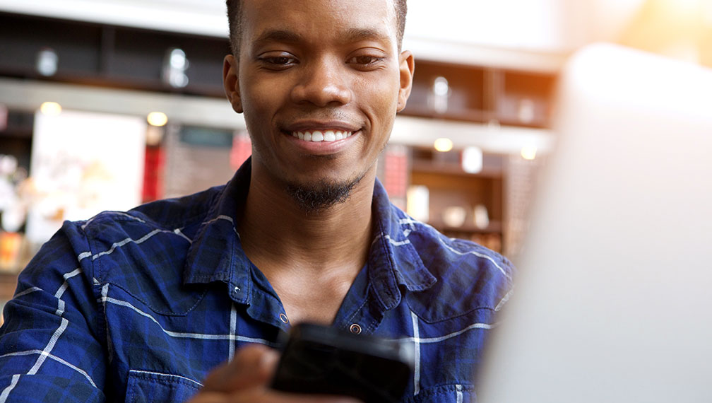 Young man looking at cell phone in store