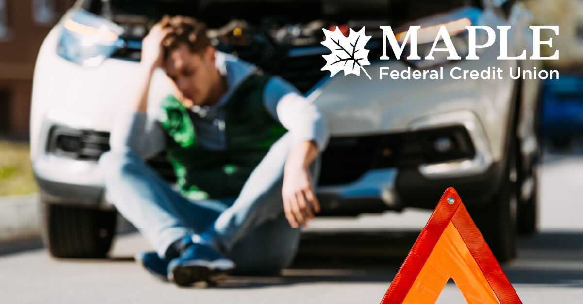 Man sitting in front of broken down car distraught