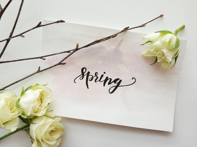 paper reading "spring" with flowers