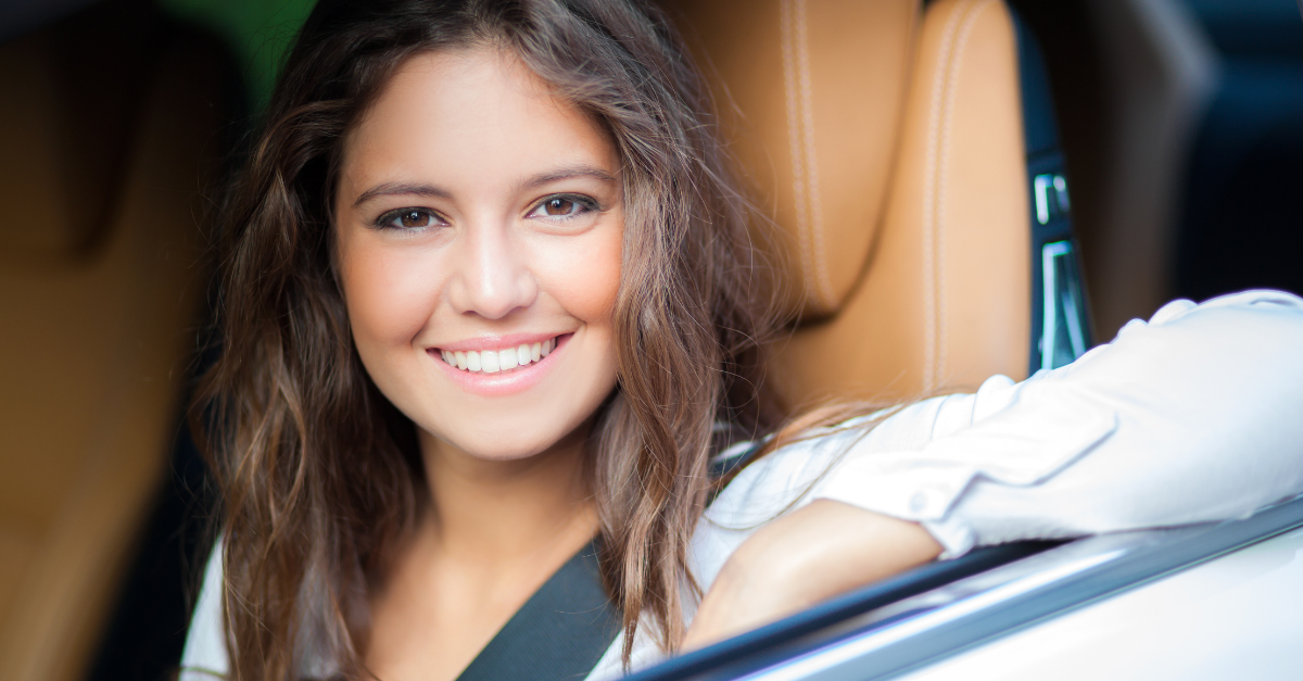 young woman smiling in a car arm resting on window