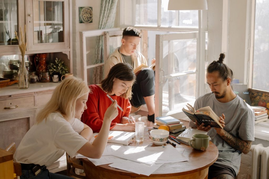 group of college students studying in a brightly lit kitchen