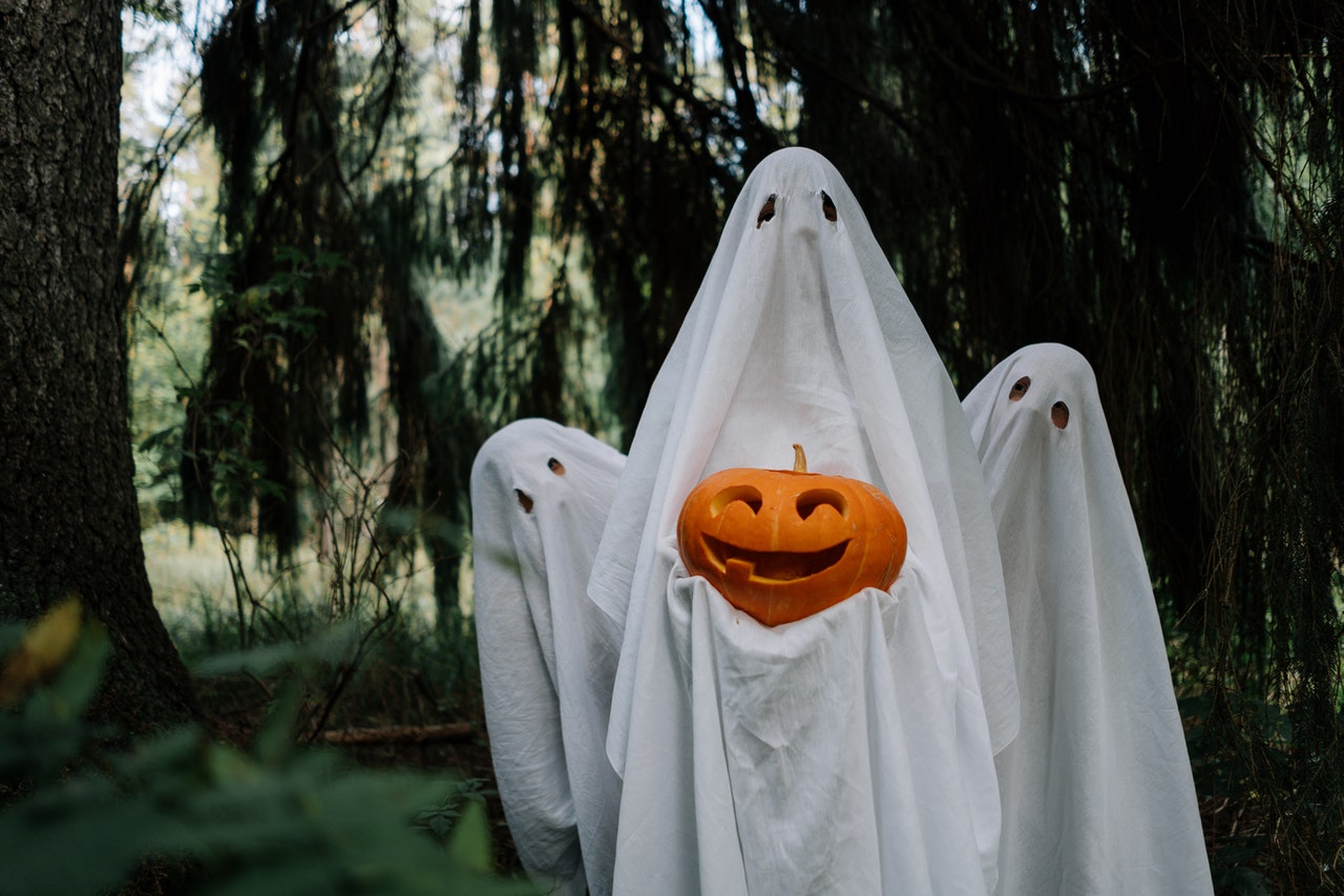 three people dressed as ghosts in the woods