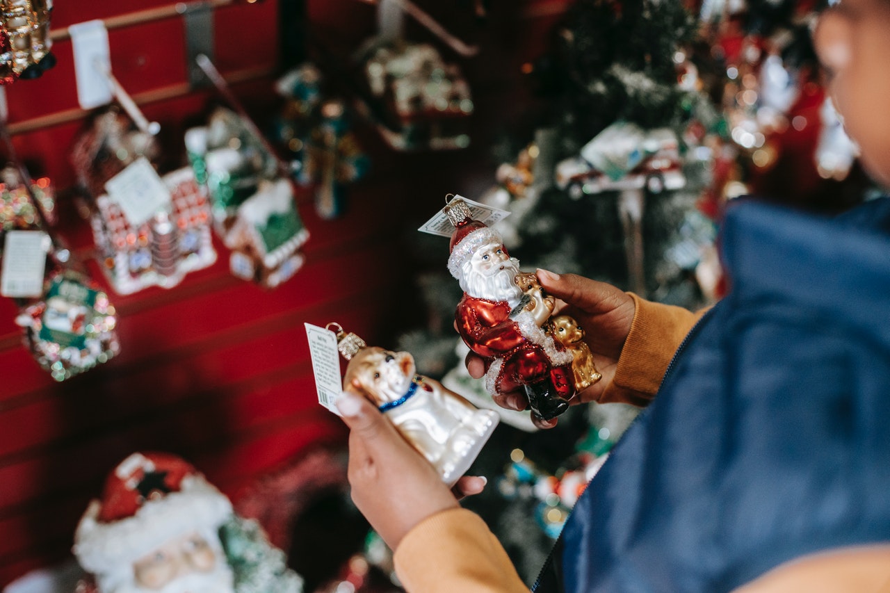 person deciding between two christmas ornaments