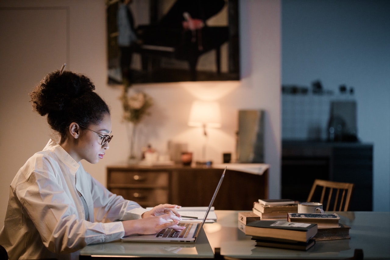 girl studying at a computer with lamp light