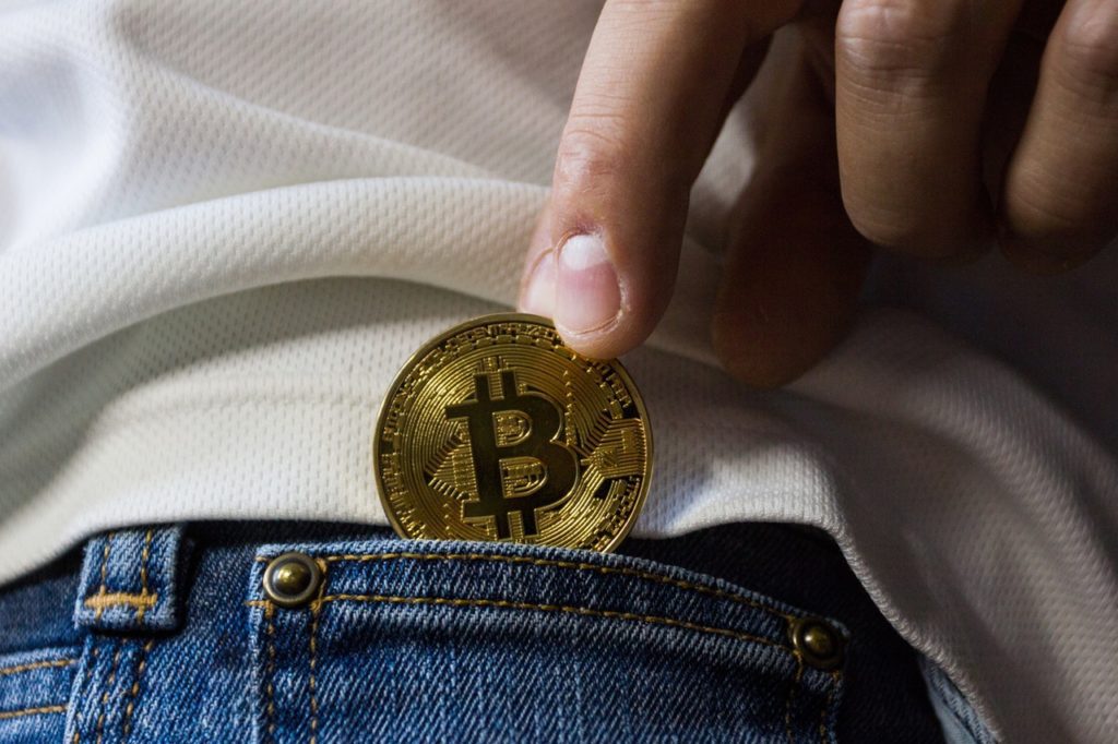person in white t-shirt and jeans with bitcoin