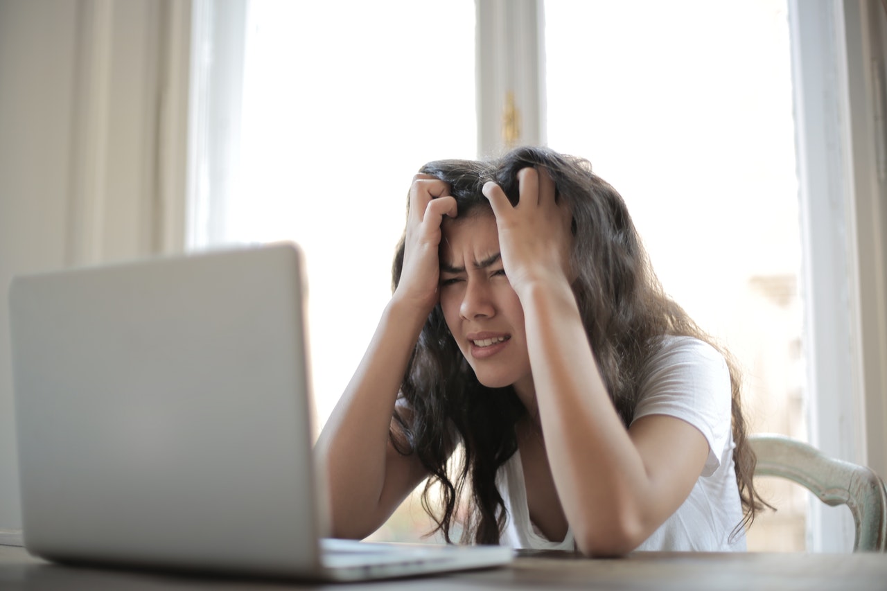 woman with hands in hair looking stressed