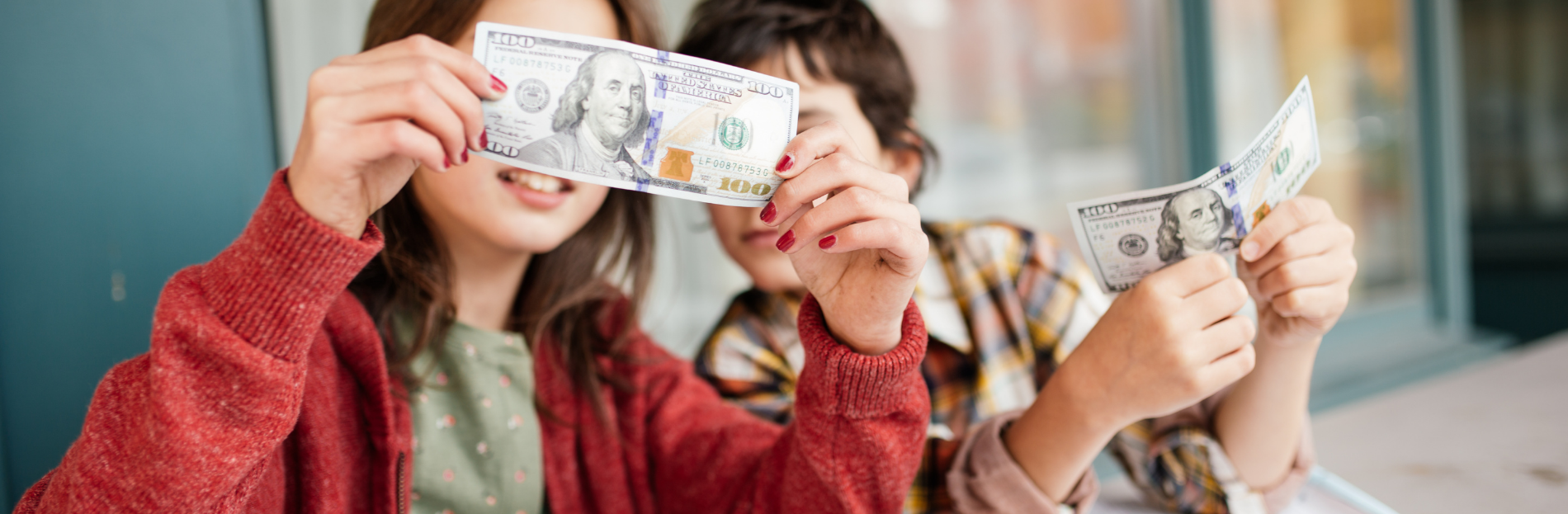 kids looking at money with notebooks