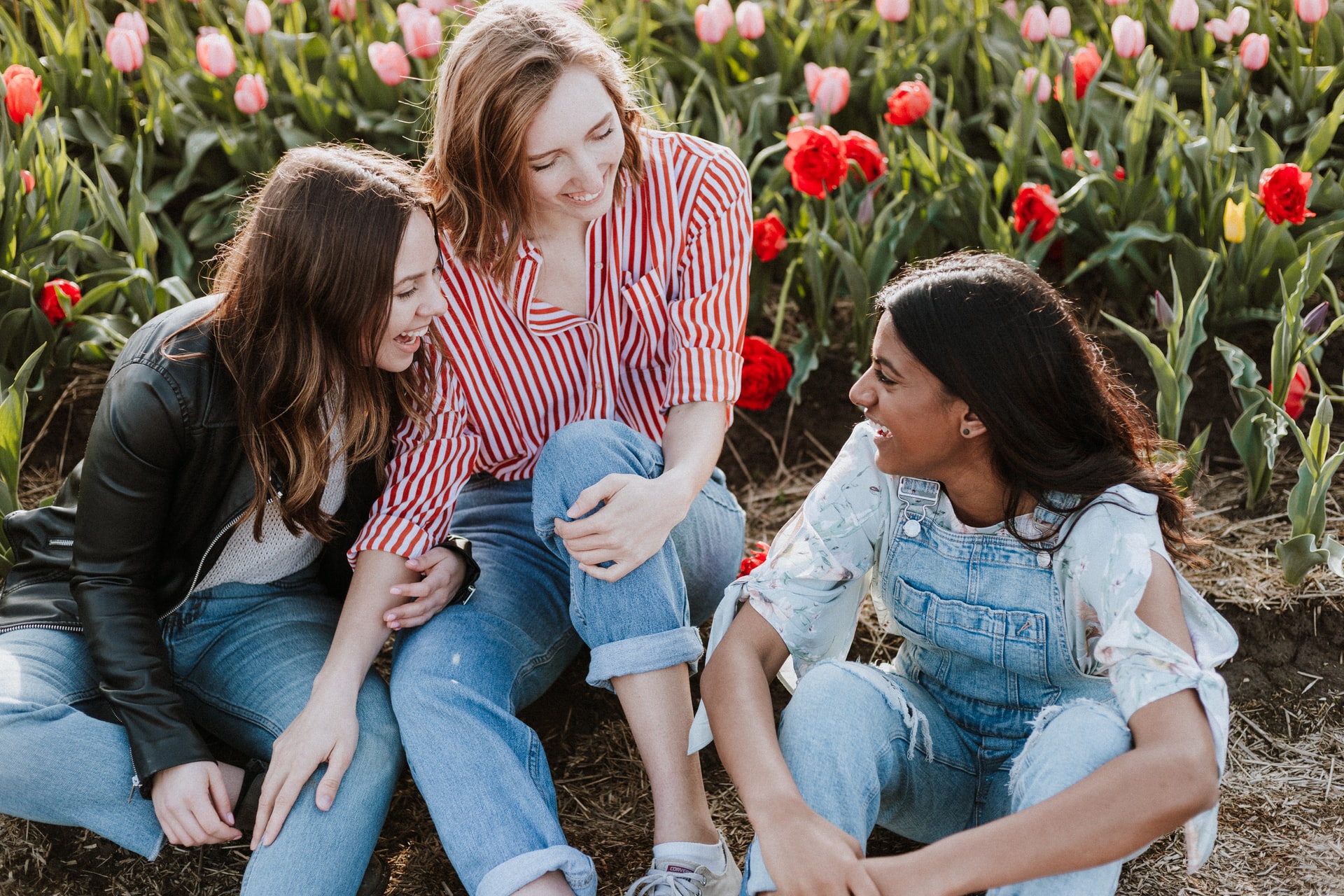 three girls among tulips smiling