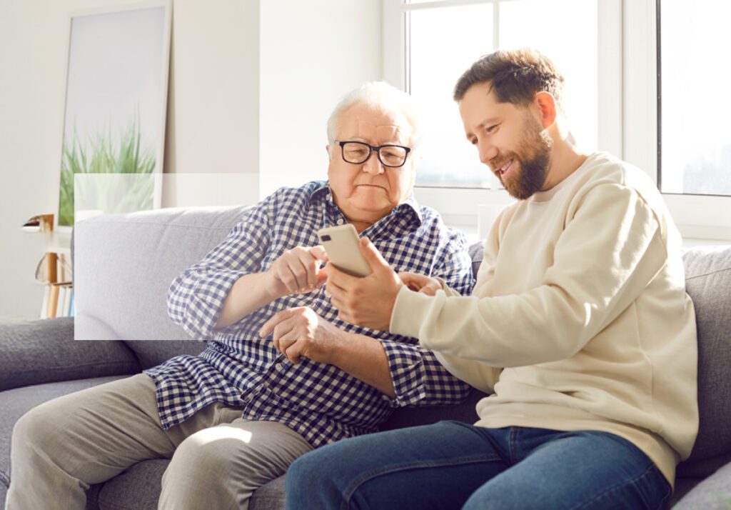 Young adult showing his phone to a Senior